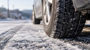霜がおりた朝の道路と、車のタイヤのイメージ写真